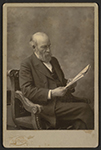 Protrait of Daniel T. Ames reading a newspaper